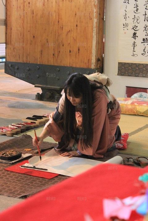 Reiko réalisant une calligraphie